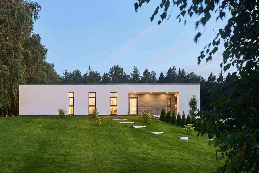 Contemporary Villa AJ front view with elevated minimalist architecture, framed terrace, and landscaped garden, designed by NG Architects